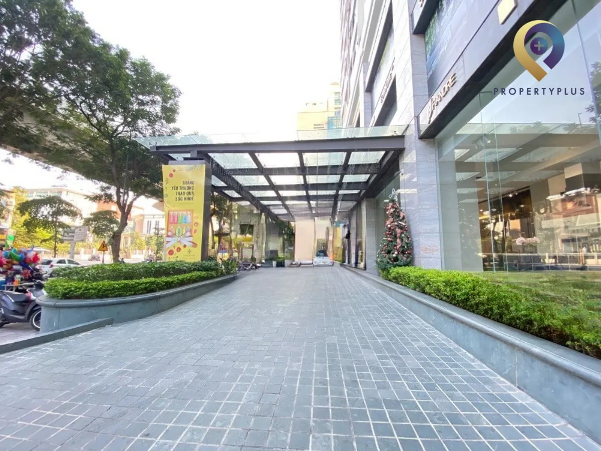 Lối vào chính tòa nhà Hoàng Cầu Skyline với mái che hiện đại, logo Property Plus.